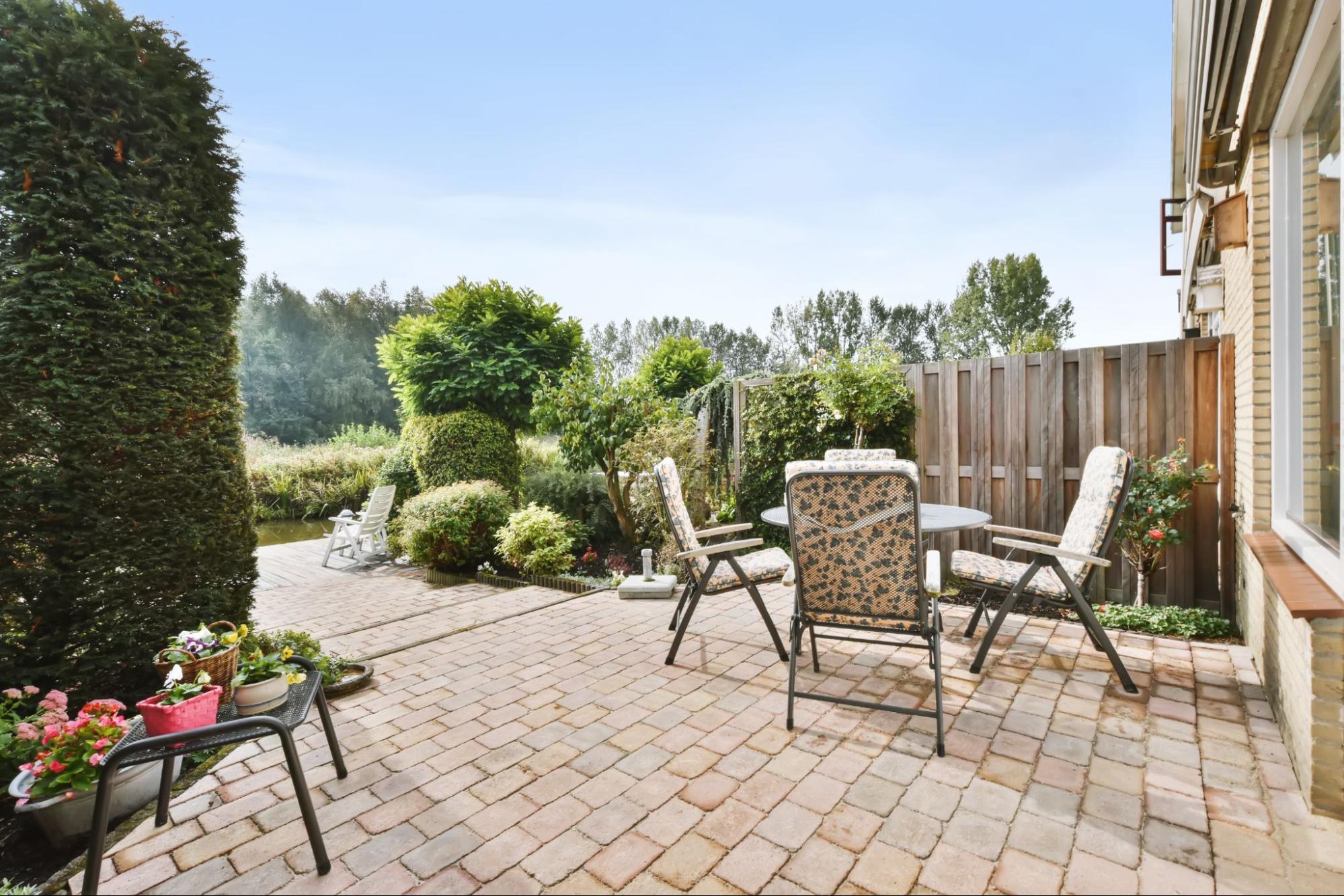 Brick paver patio with outdoor dining set surrounded by mature landscaping in Cicero, IL by Luxterra Outdoors